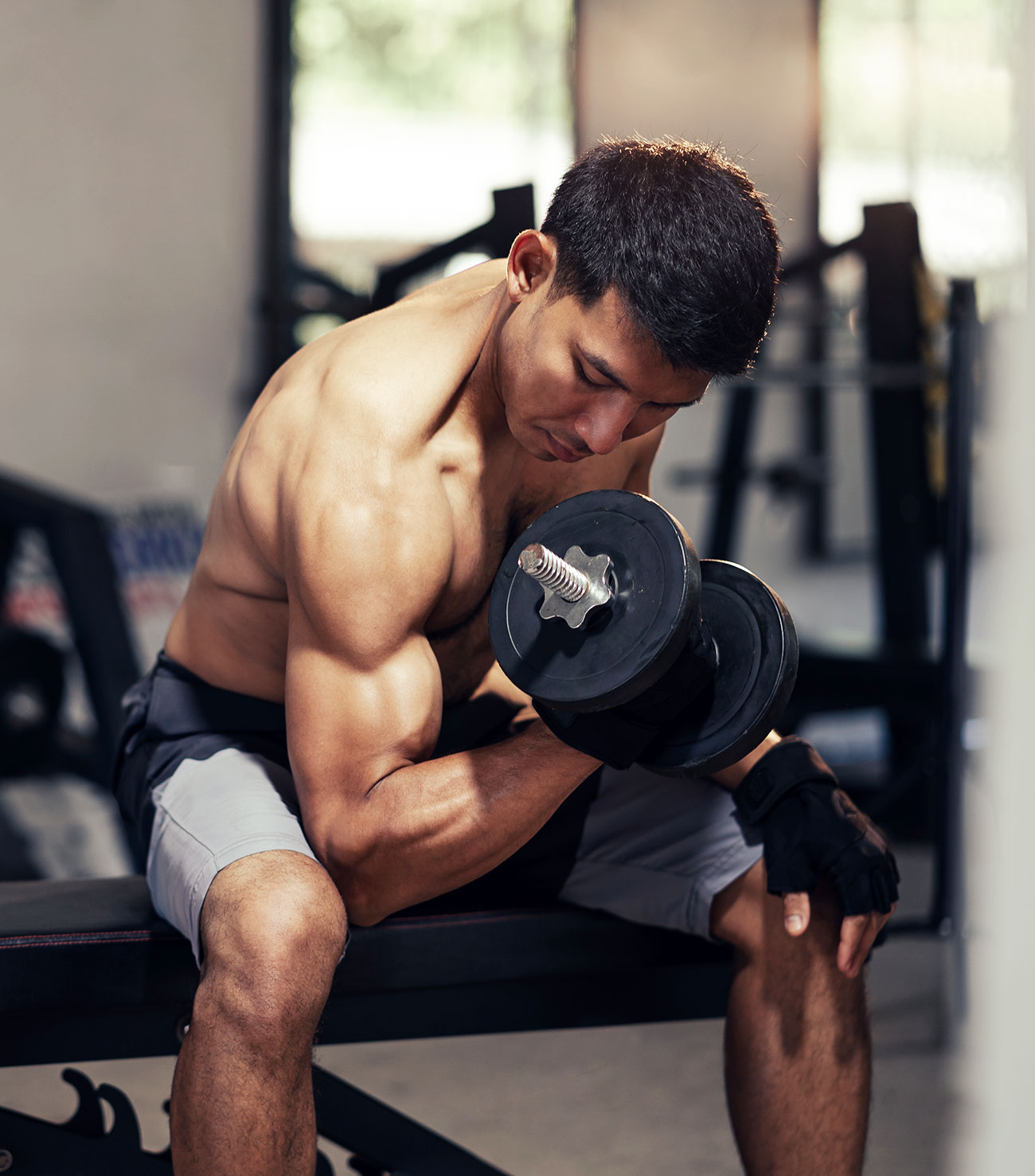 Dark Haired Man Shirtless Lifting Dumbell With Right Arm